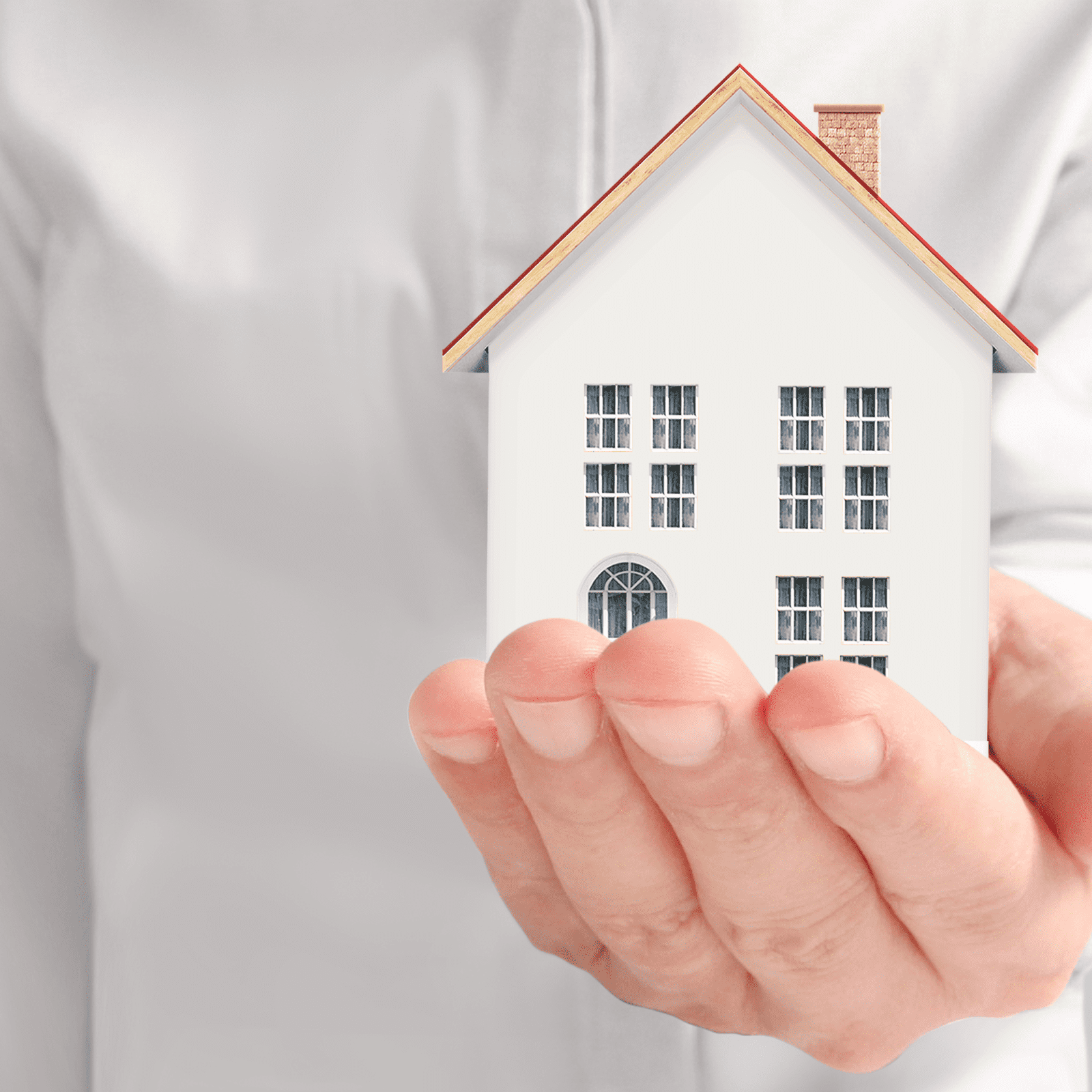 Man holding a model house in his hand